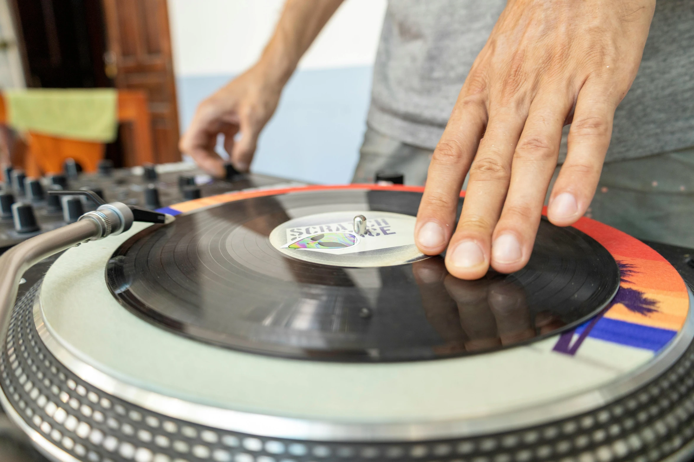 a close - up of a dj with one hand on a dj's turntable