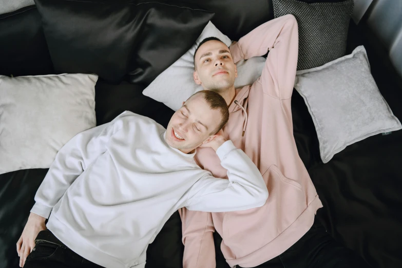 a couple of people that are laying on some pillows