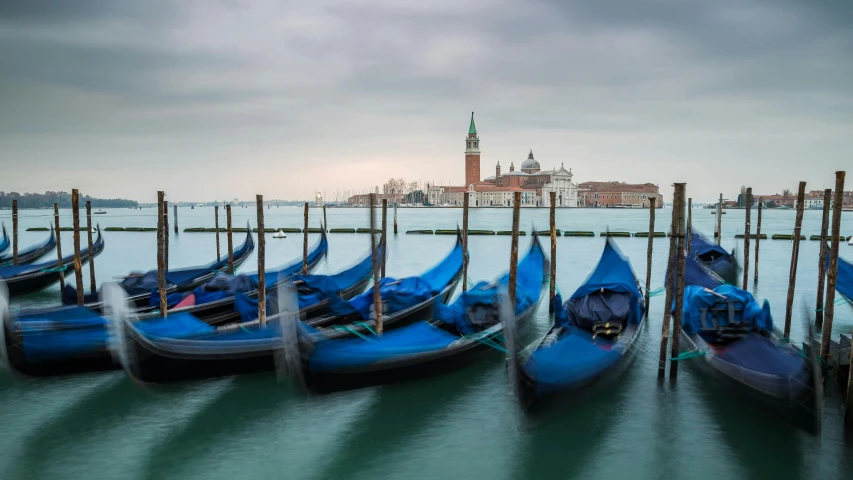 a number of boats parked at a dock near a body of water