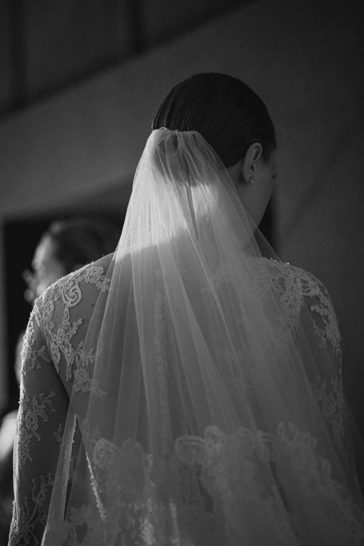 a woman with a veil on her head is in front of the window