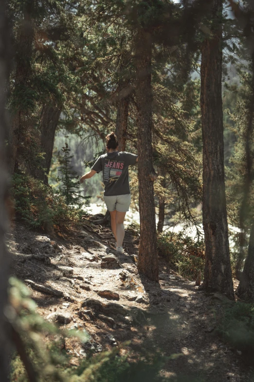 a man that is walking across a path in the woods