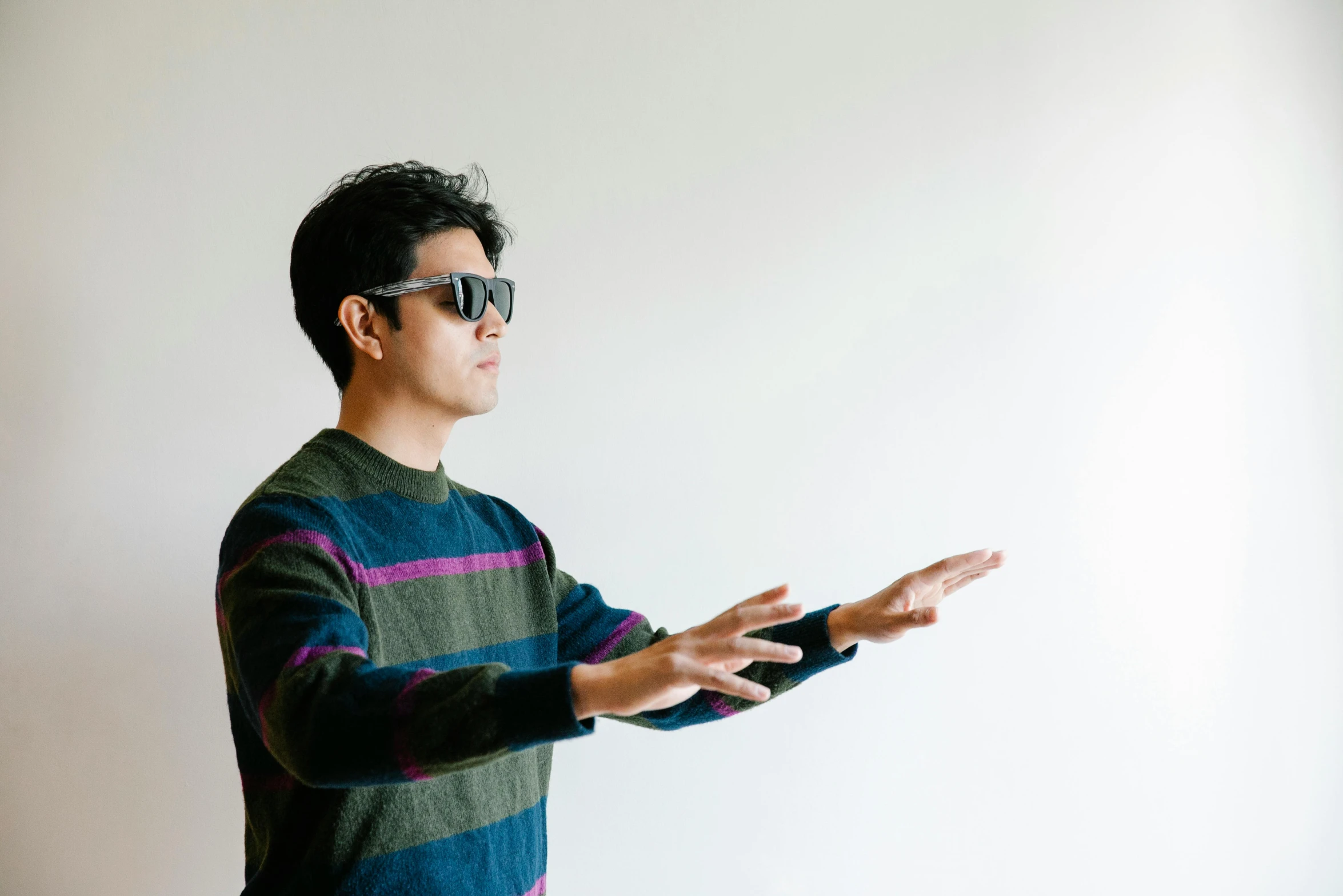 an asian man in shades holding out his hands