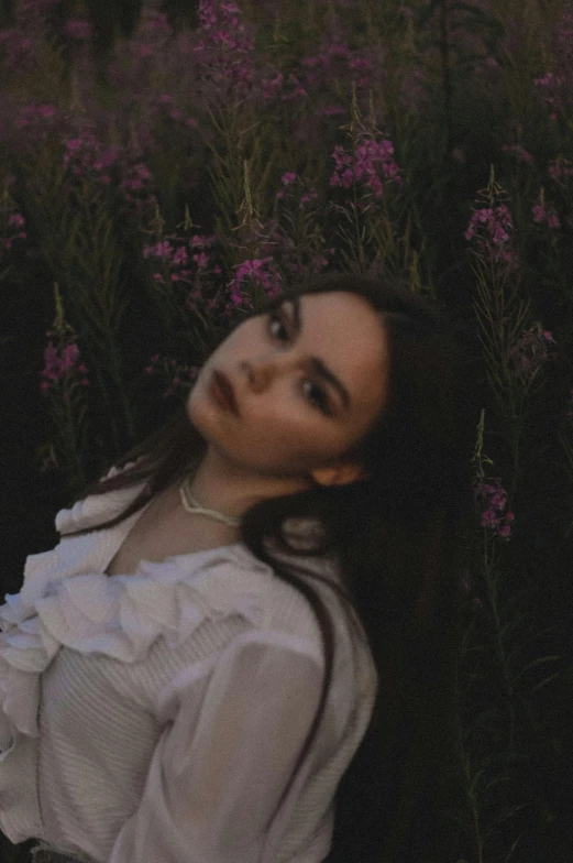 a woman sits in the grass with her head propped against the ground