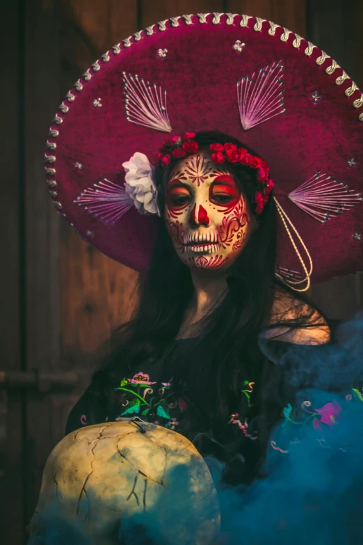 a woman with makeup and a hat in the day of the dead
