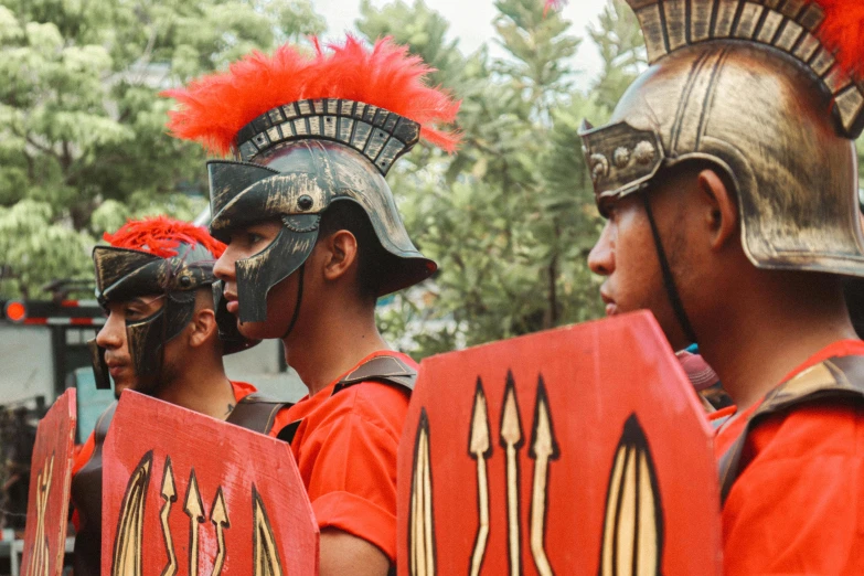 four roman warriormen are holding signs on the side of their bodies