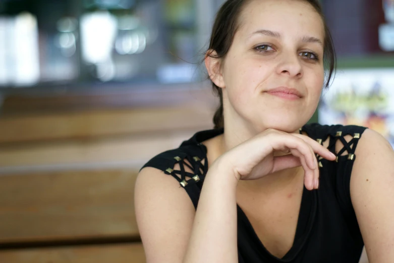 a girl with brown hair and black top sitting in a church