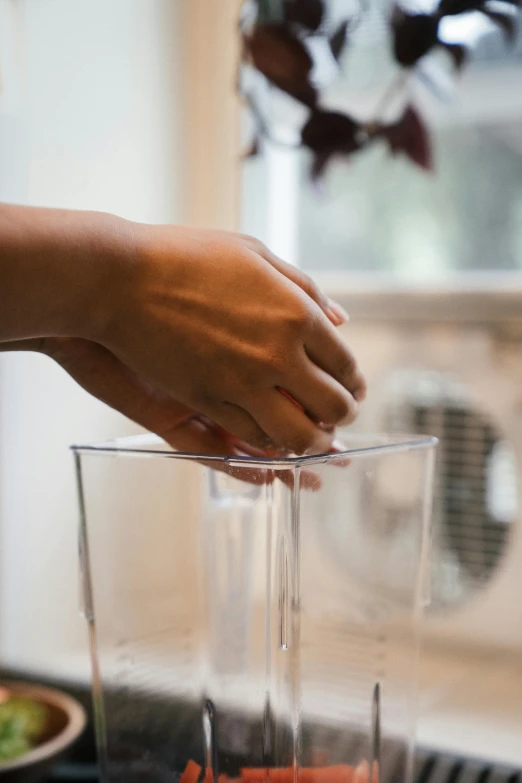 someone pouring a drink in to a glass from a blender