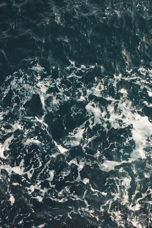 the surface of the water has lots of foamy white waves