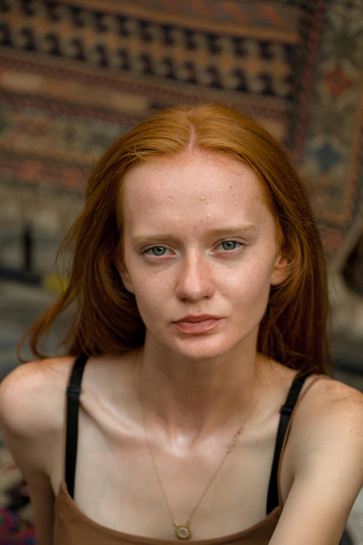 a woman with red hair looks at the camera