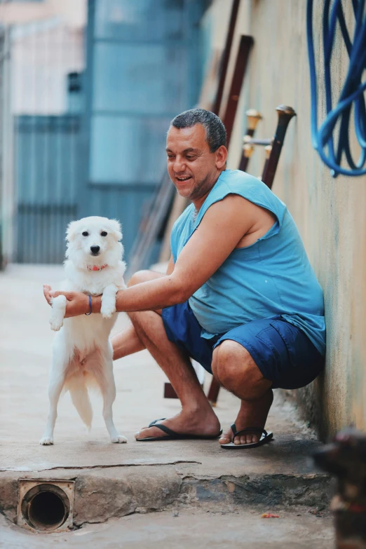 a man holding a white dog and posing for a po