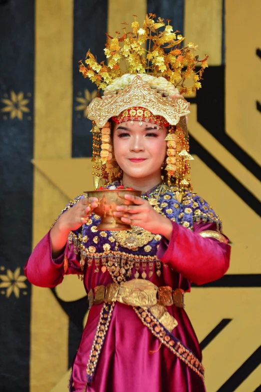 a girl in traditional attire holding a candle