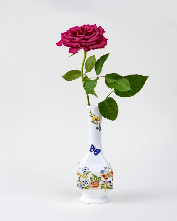 a beautiful pink rose in a white vase