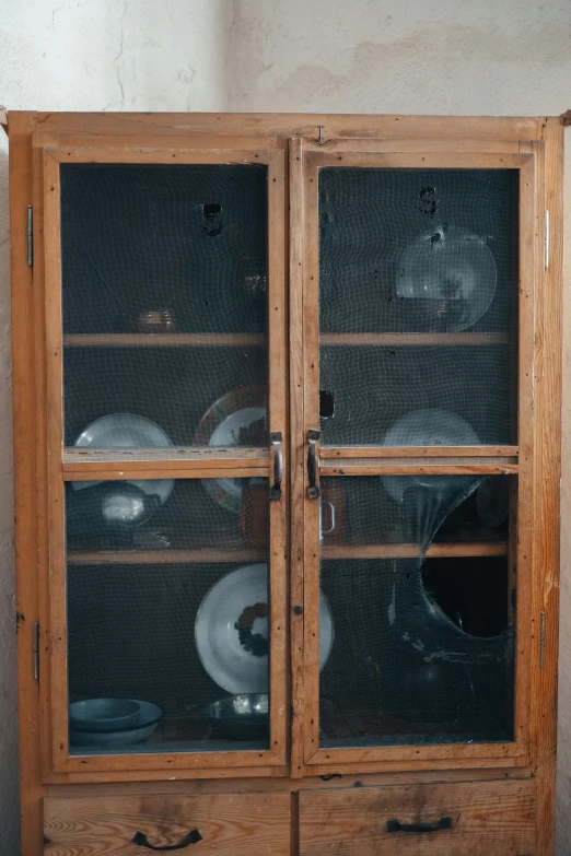 this old wooden cabinet is displaying plates and other items