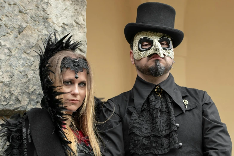 man and woman in costumes standing near a rock wall