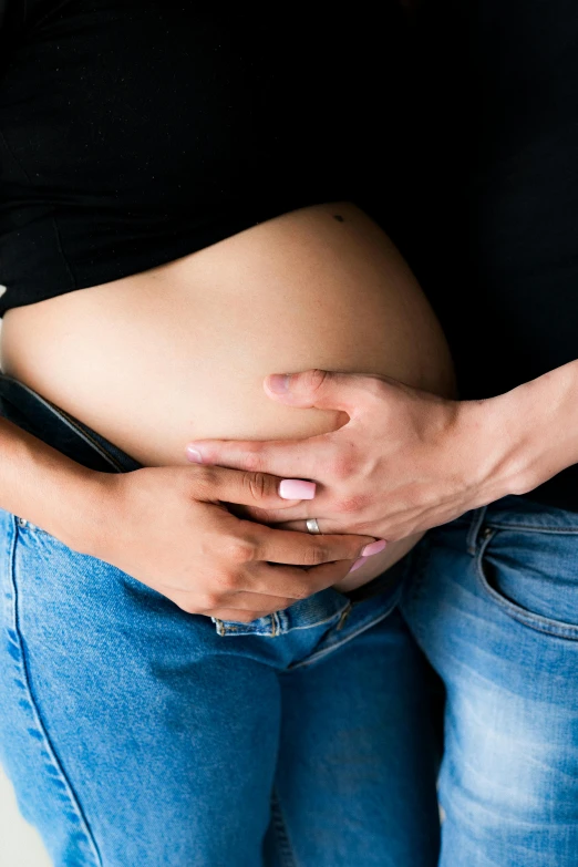 an image of a pregnant woman holding her hand on her belly