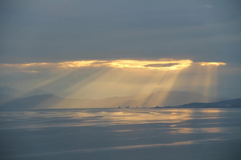 a bright light shines through the clouds over water