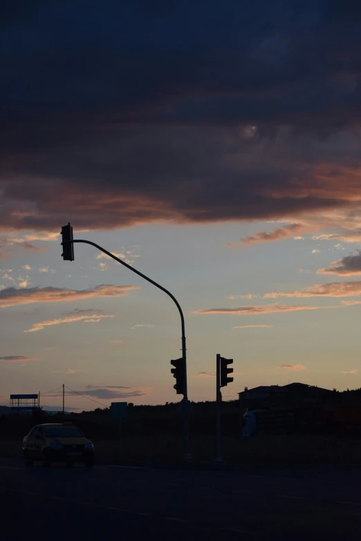 the street light shines brightly as the sun sets