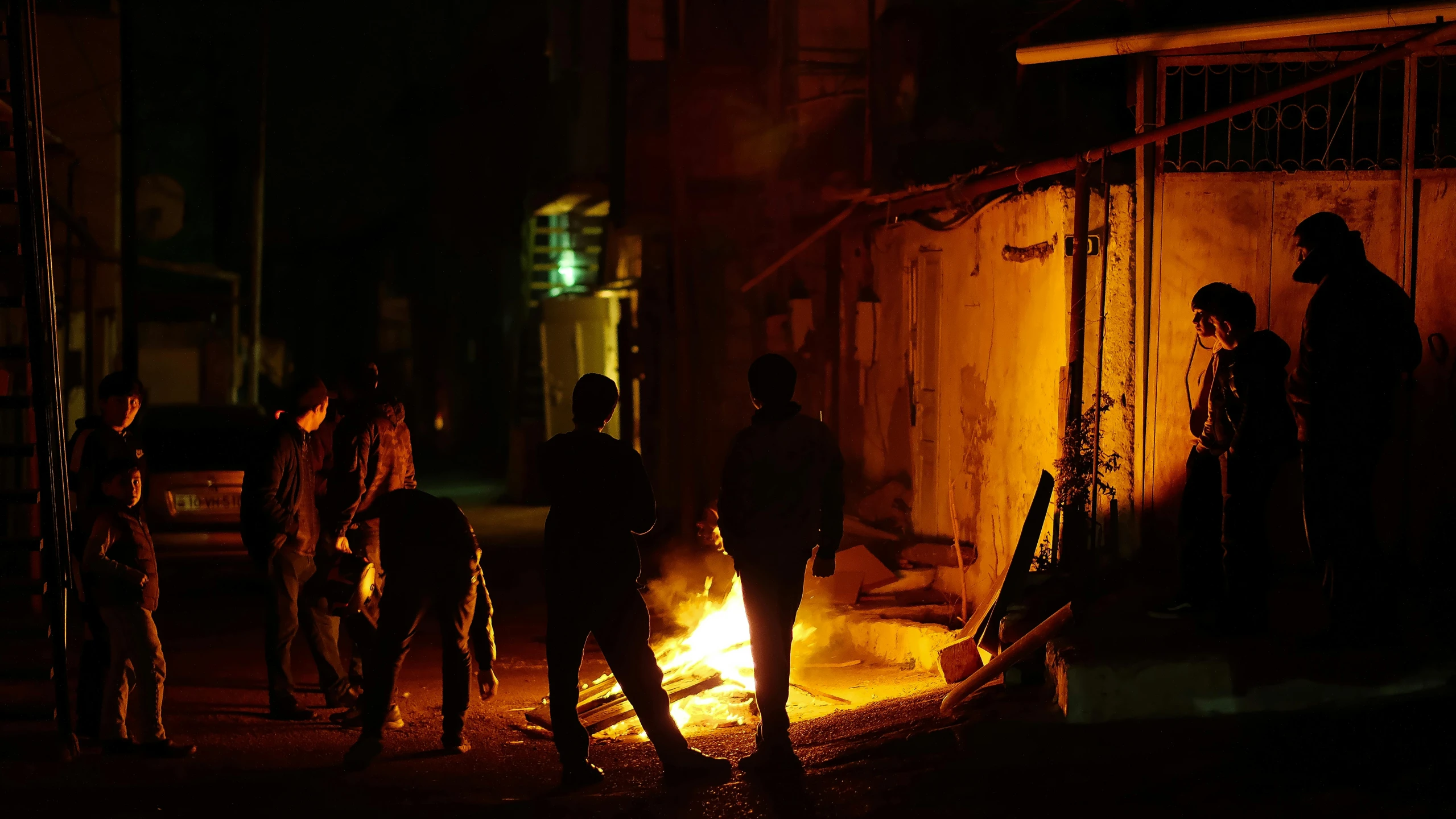 a group of people walking along side of a fire