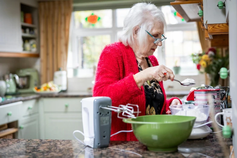 an old woman is preparing a salad in the kitchen