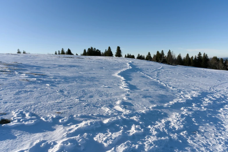 a path in the snow next to a hill