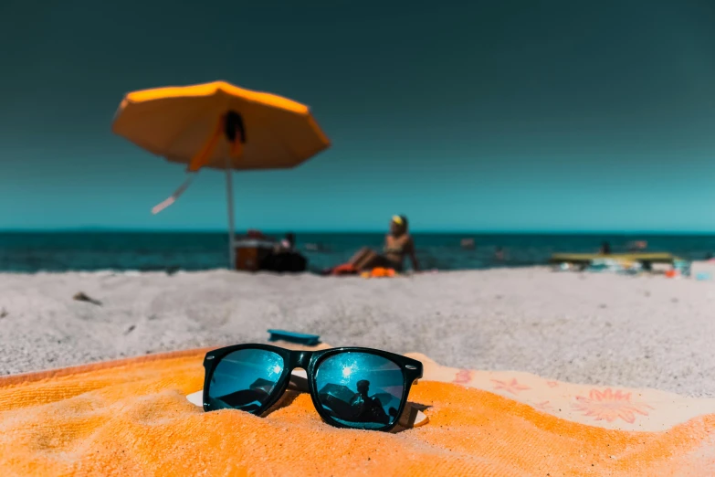 some sunglasses laying on top of a sandy beach