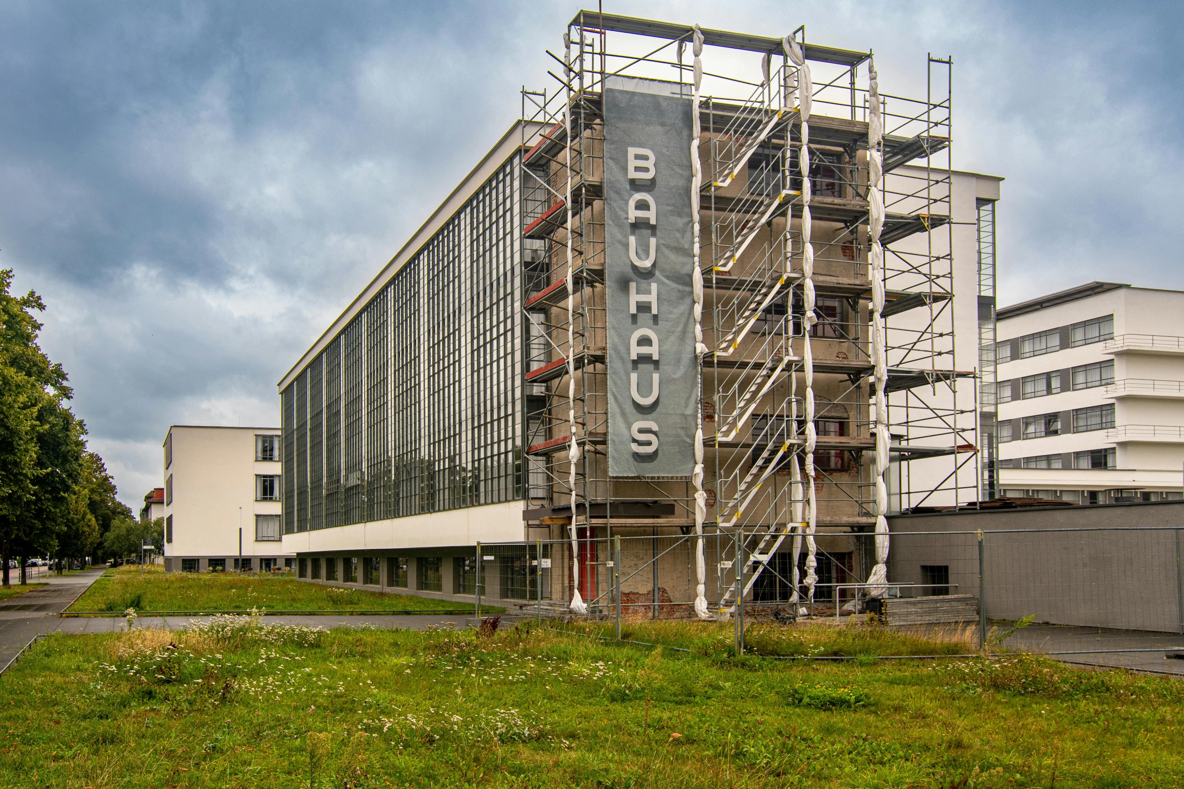 a building being built in the middle of a grass area with scaffolding around it