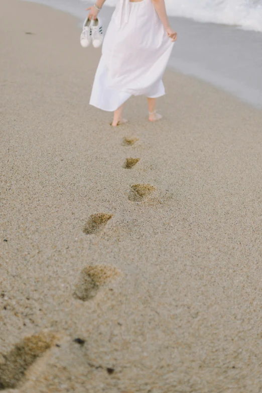 a person walking on the sand and a foot print