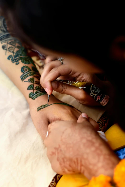 a man is getting tattoos done on his hand