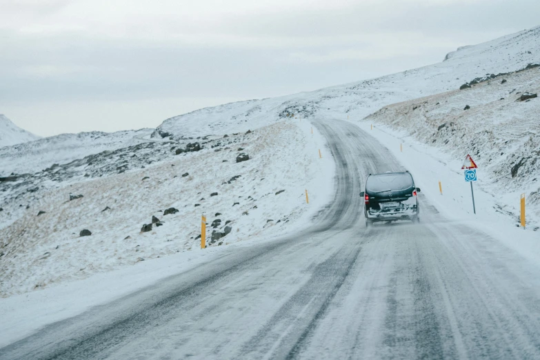 two people walking down a snowy path by a car