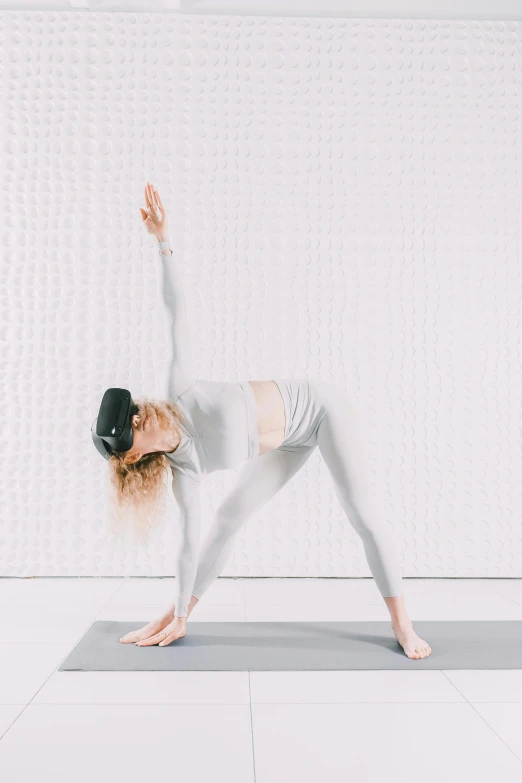 a woman practices yoga in a white room