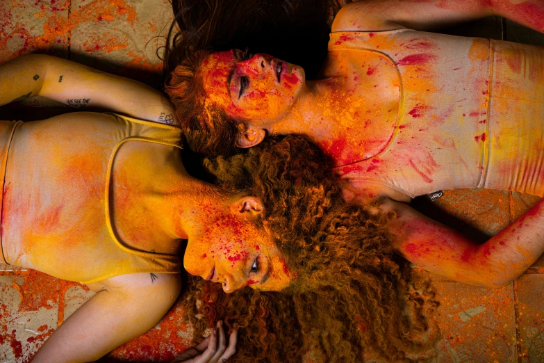 two women are dressed as their bodies covered in orange paint