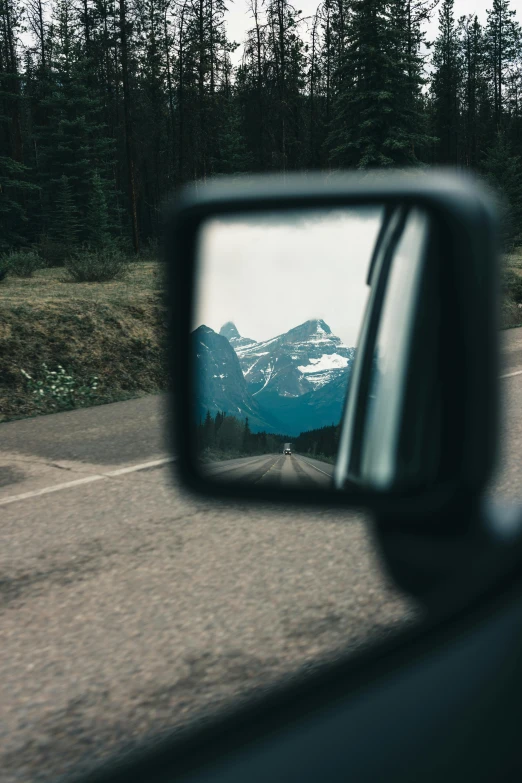 a car side mirror on the side of a road