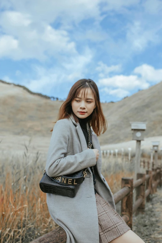 a woman is sitting on the edge of the fence