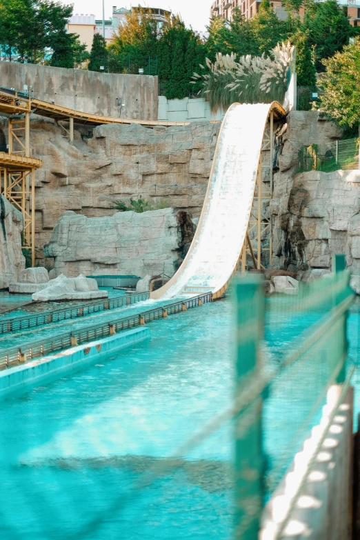 a man rides a water slide in an outdoor pool