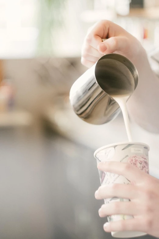 a person pouring a beverage into a cup