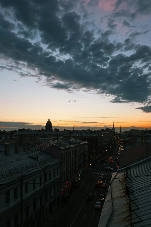 some cars parked on the street with a cloudy sky in the background