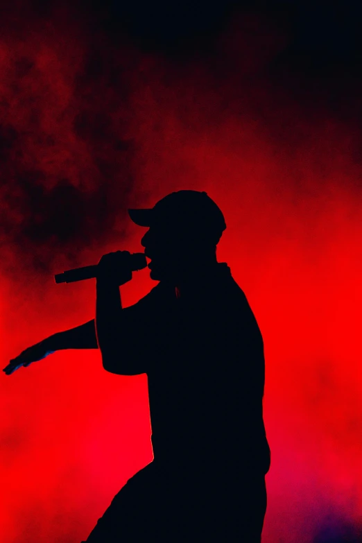 a silhouette of a man on a microphone