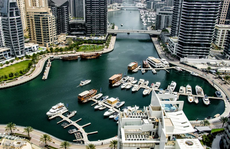 a harbor filled with boats next to tall buildings