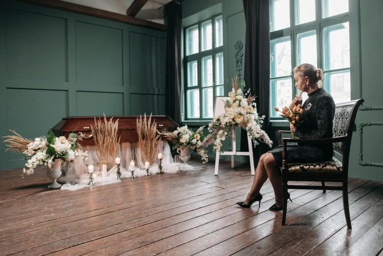 a woman sitting in a chair on top of a wooden floor