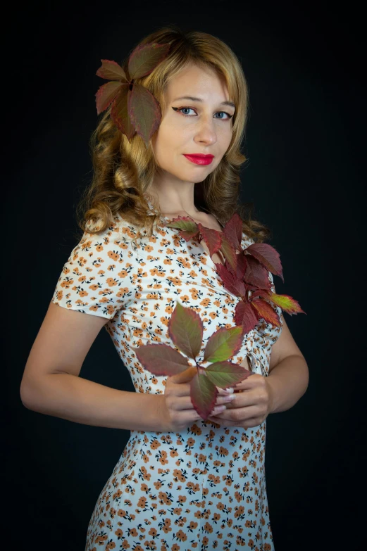 woman in floral print dress holding leafed plants