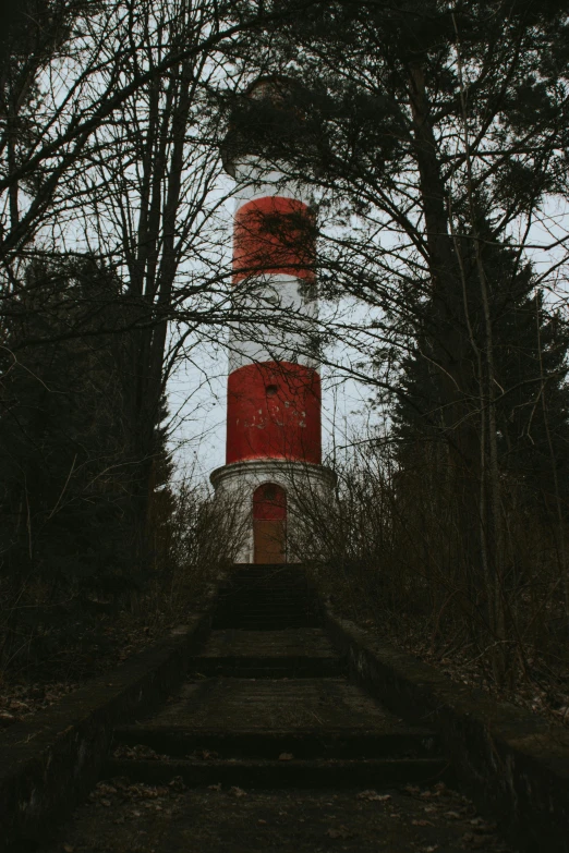 a light house with trees and bushes around it