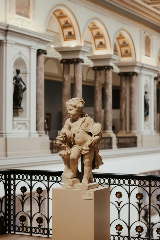 an antique statue of an angel holding a bowl with a marble figure