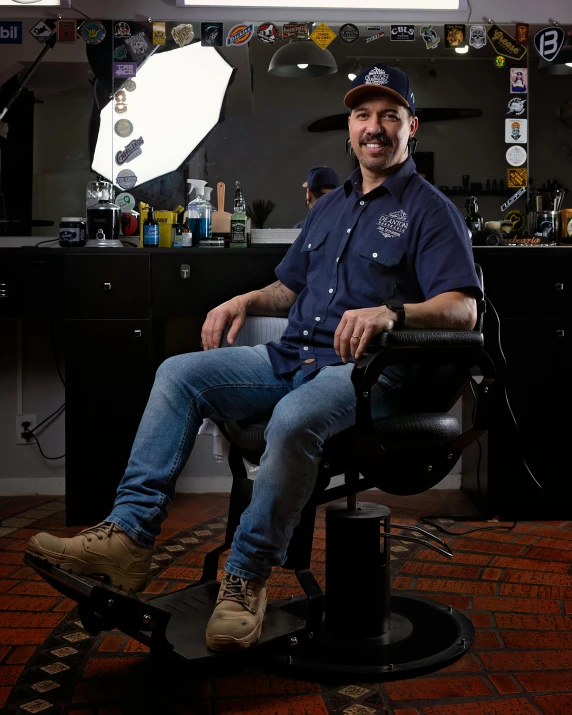 a man sitting in a barber chair holding a bottle