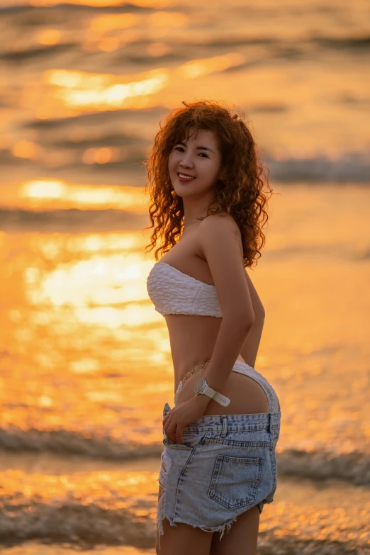 a  young woman standing on top of a beach