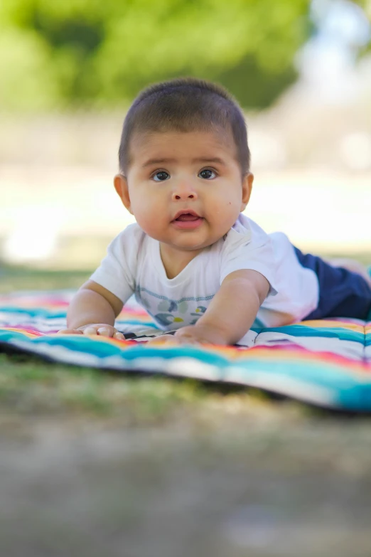 a baby is laying on his back on the blanket