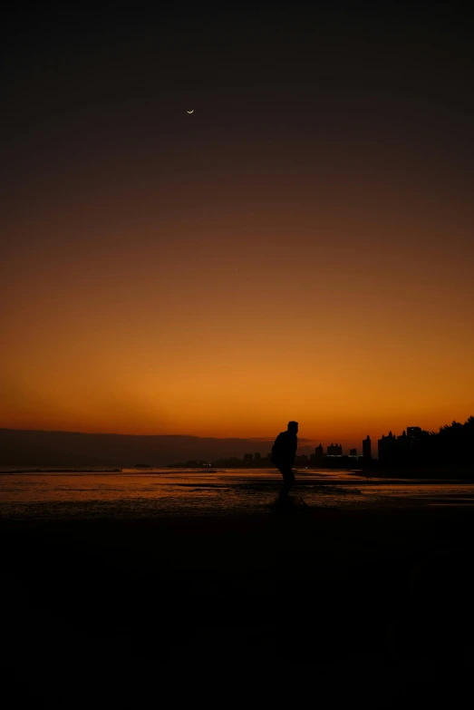 people are standing in the ocean watching the sun rise