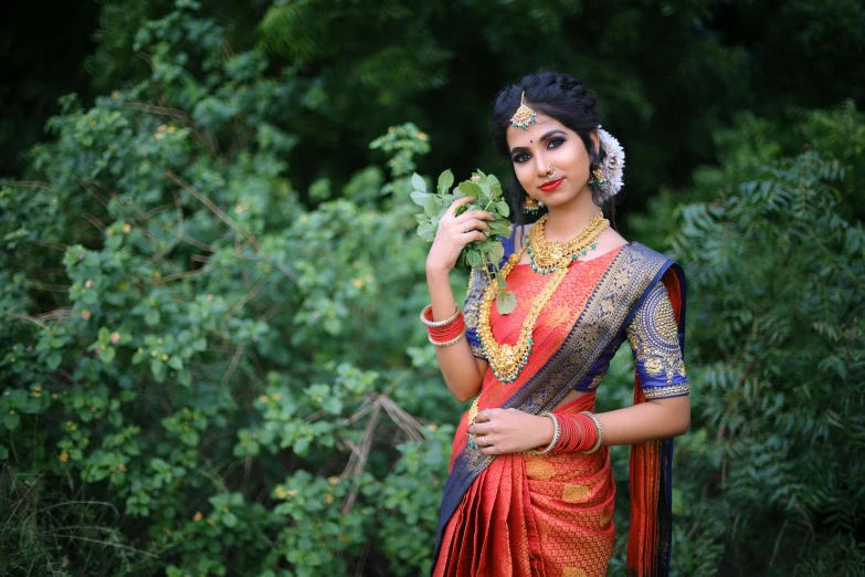 woman with necklaces and jewelry holding green plant