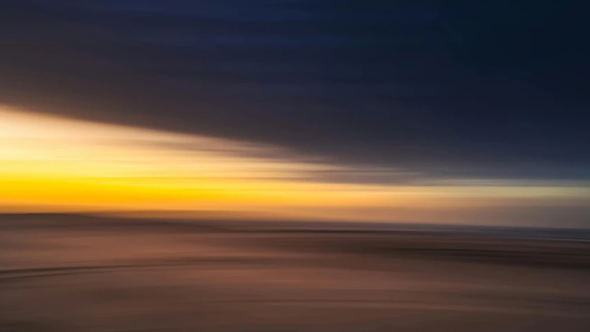 a beach with waves coming in and some sky