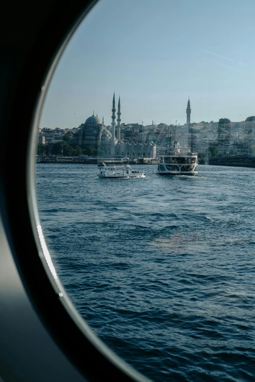 boats in water with a skyline as seen from outside a window