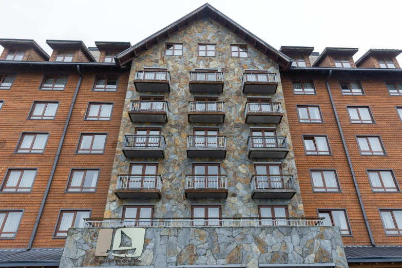 a building with a balcony on top next to a wall